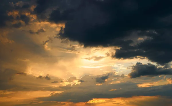 背景には美しい夕焼け空明るい太陽と暗い雲のシルエット — ストック写真