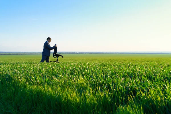 ビジネスマンは仕事 フリーランス ビジネスのコンセプト 緑の草と青空を背景にオフィスチェアを持っています — ストック写真