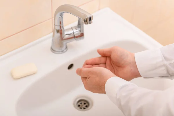洗面台の水の下で石鹸やゲルで手を洗う 清潔と衛生 白いシャツを着た男性の手 — ストック写真