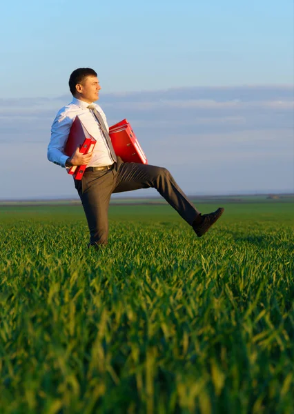 Adamı Yeşil Çimlerin Üzerinde Yürür Elinde Bir Ofis Kırmızı Klasörü — Stok fotoğraf