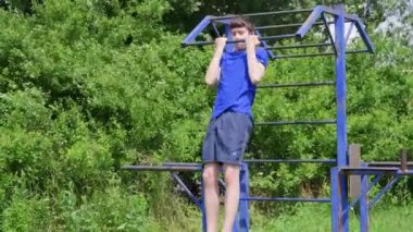 Dışarıda spor yapan genç bir çocuk bahçede spor yapıyor. Isınma ve sağlıklı bir yaşam sürüyor.