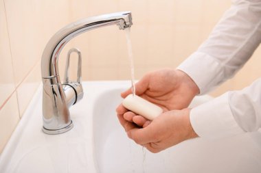 Yıkanırken sabun ya da jöle, lavaboda akan su, temizlik ve hijyen, beyaz gömlek giymiş erkek elleri.