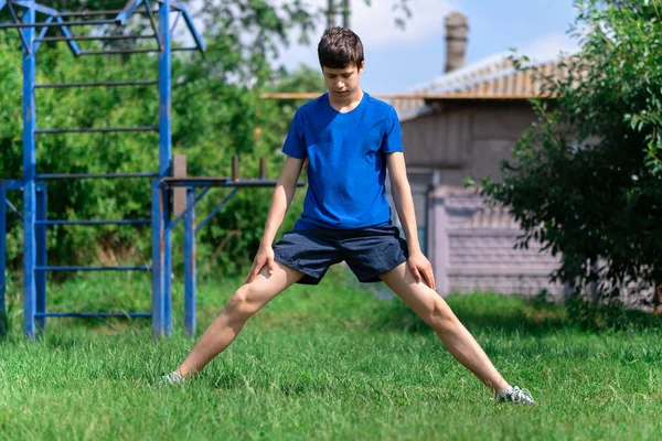 Jugendlicher Turnt Freien Sportplatz Auf Dem Hof Hockt Und Macht — Stockfoto