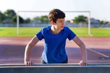 Stadyumun kenarındaki bir adam şınav çekiyor, sağlıklı bir yaşam tarzı.