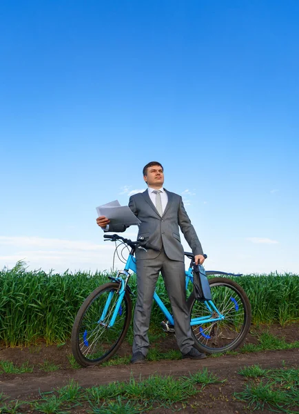 自転車を持つビジネスマンは 緑の芝生のフィールドで文書で動作します 休暇やフリーランスのためのビジネスコンセプト 美しい春の自然 — ストック写真