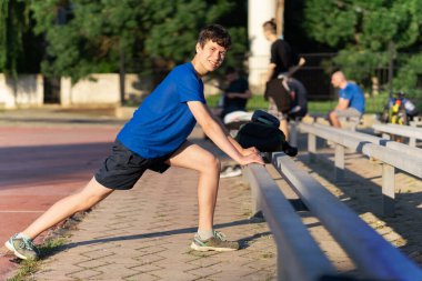 Stadyumun kenarındaki bir adam ısınıyor, sağlıklı bir yaşam sürüyor.