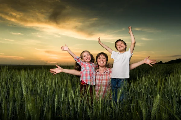 Família feliz ao pôr do sol — Fotografia de Stock