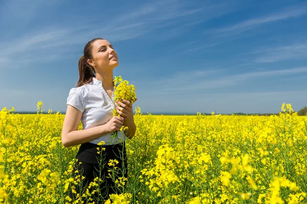 Frau im gelben Blumenfeld — Stockfoto