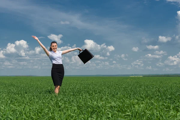 Donna con una valigetta che cammina sull'erba — Foto Stock