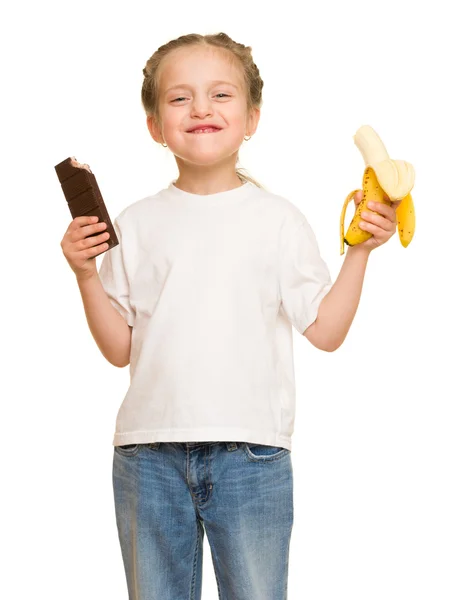 Liten jente spiser banan og sjokolade – stockfoto