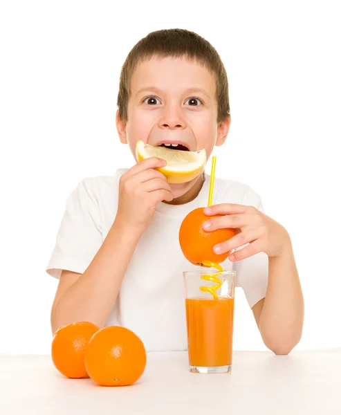 Niño beber jugo de naranja con una paja — Foto de Stock
