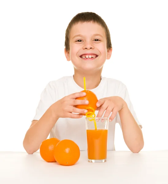 Niño beber jugo de naranja con una paja —  Fotos de Stock