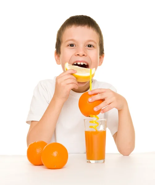 Niño beber jugo de naranja con una paja —  Fotos de Stock