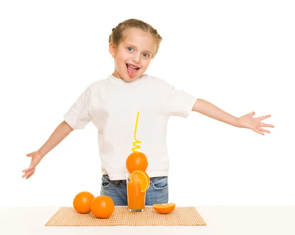 Liten flicka med apelsiner dricka saft med sugrör — Stockfoto