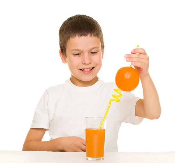 Niño beber jugo de naranja con una paja — Foto de Stock