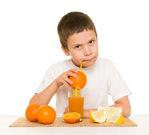 Boy drink orange juice with a straw — Stock Photo, Image