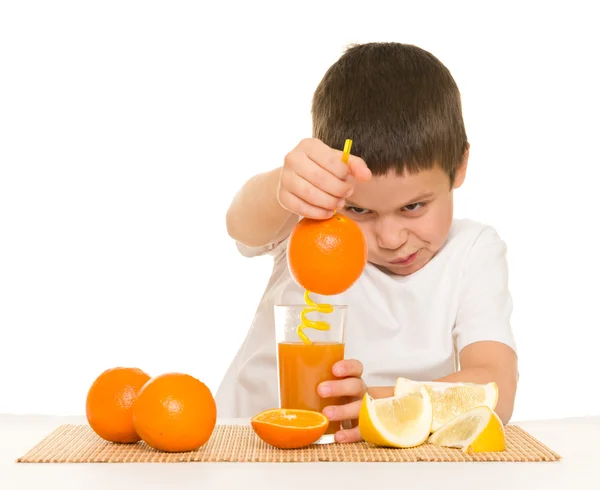 Menino beber suco de laranja com uma palha — Fotografia de Stock