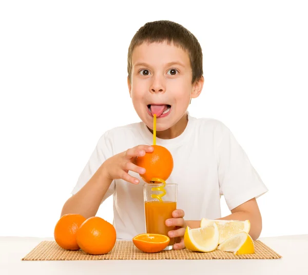 Menino beber suco de laranja com uma palha — Fotografia de Stock