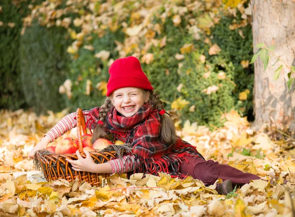 Petite fille dans le parc d'automne avec panier de pomme — Photo