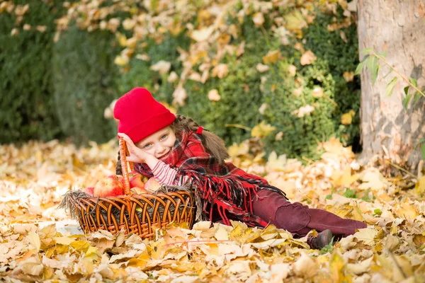 Little girl in autumn park with apple basket — Stock Photo, Image