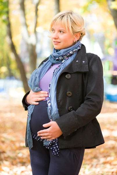 Беременная женщина в осеннем парке — стоковое фото