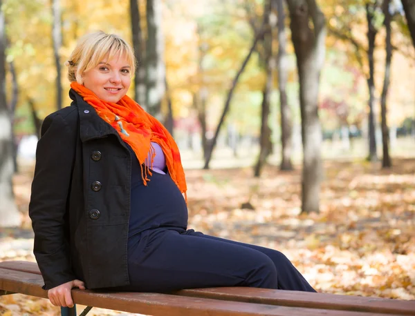 Mulher grávida no parque de outono — Fotografia de Stock