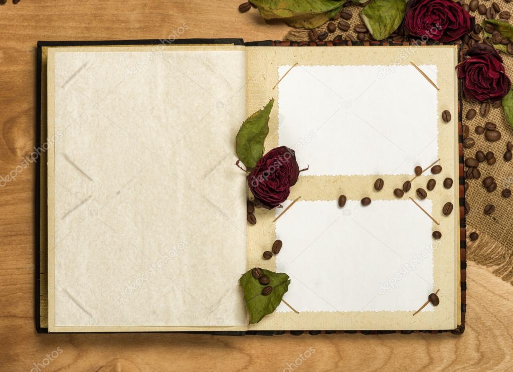 photo album and dry red roses on coffee seeds
