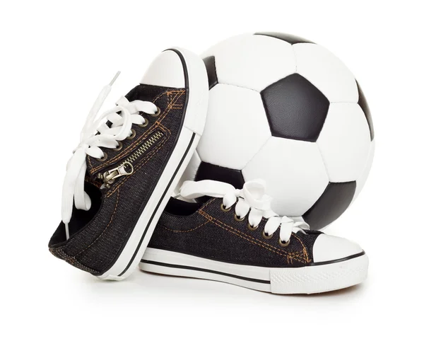 Fotbalový míč a sportovní boty na bílém pozadí — Stock fotografie
