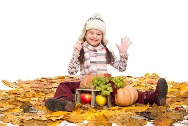 Menina com frutas e legumes em folhas de outono — Fotografia de Stock