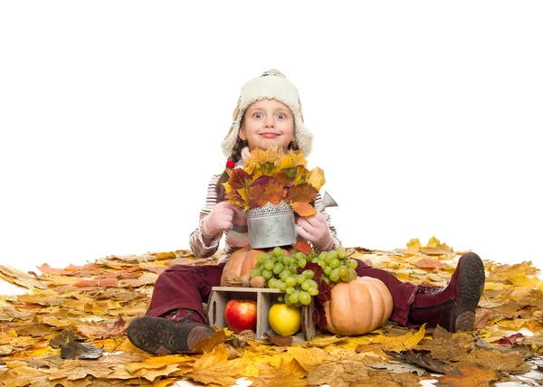 Menina com frutas e legumes em folhas de outono — Fotografia de Stock
