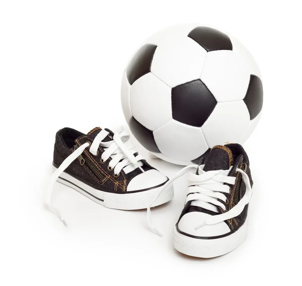 Bola de futebol e sapatos esportivos em branco — Fotografia de Stock