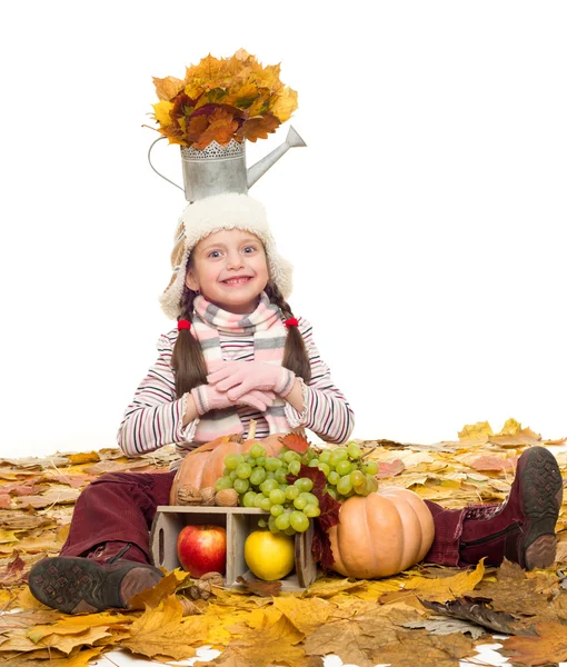 Menina com frutas e legumes em folhas de outono — Fotografia de Stock