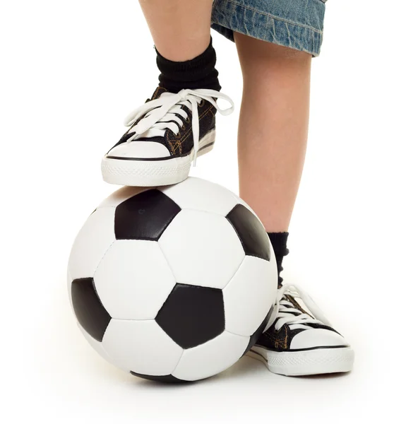 Nohy na nohou tenisky a fotbalový míč — Stock fotografie