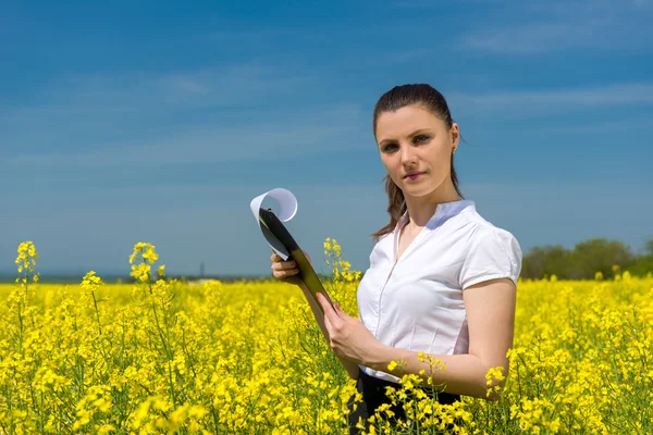 Fille avec des fleurs jaunes et lime sur le terrain — Photo