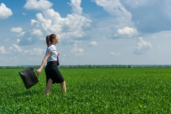 Çimenlerin üzerinde yürüyüş evrak çantalı kız — Stok fotoğraf