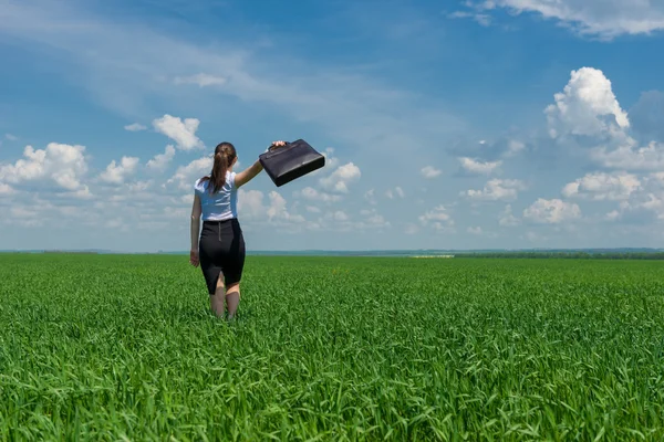 Mädchen mit Aktentasche läuft im Gras — Stockfoto