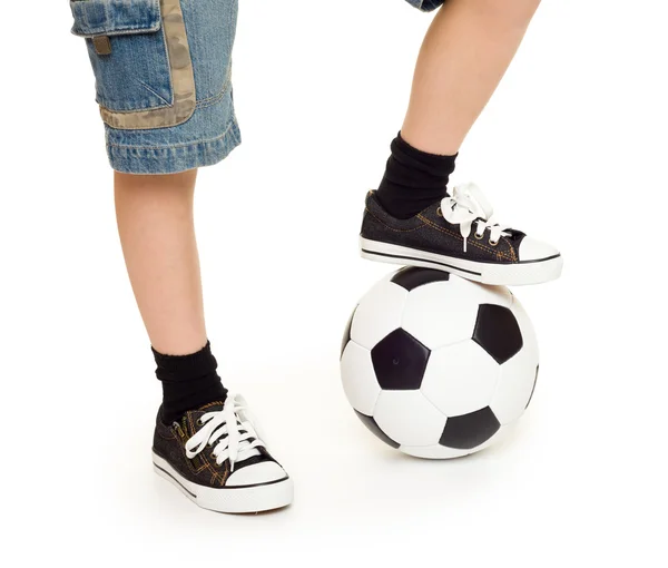 Nohy na nohou tenisky a fotbalový míč — Stock fotografie