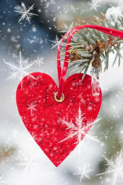 Red heart toy with snowflake on fir tree — Stock Photo, Image