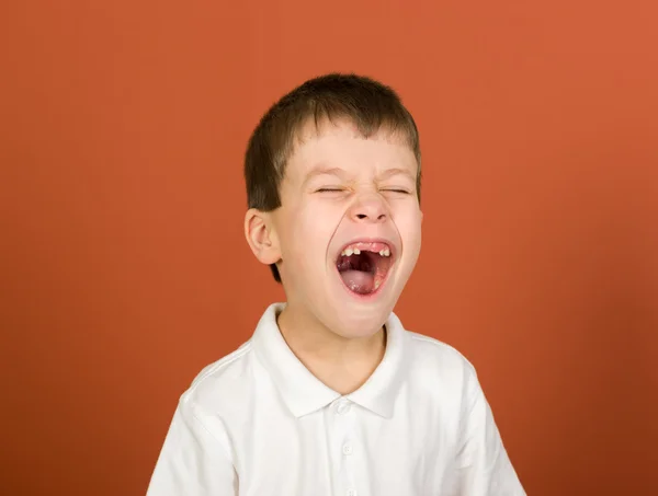 Grimaserande pojke porträtt på brown — Stockfoto
