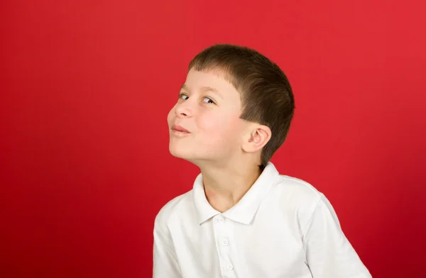 Grimacing boy portrait on red — Stock Photo, Image