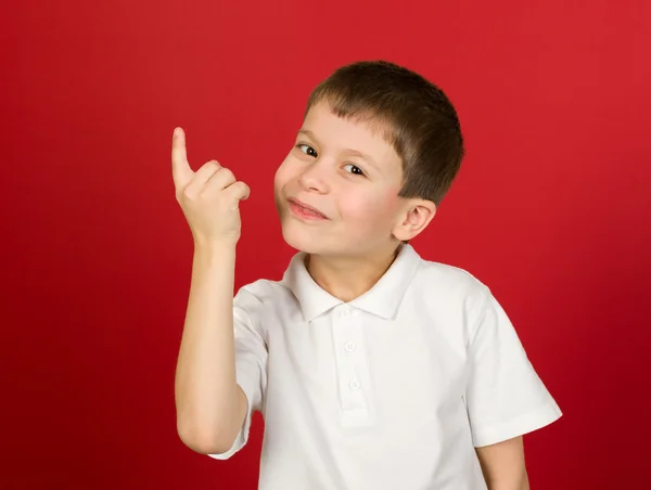 Grijnzende jongen portret op rood — Stockfoto