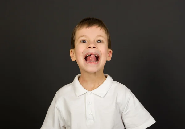 Гримасовый портрет мальчика на черном — стоковое фото