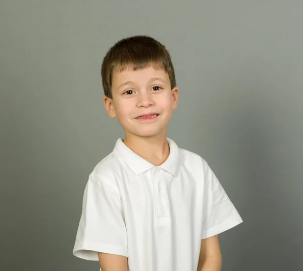 Šklebících portrét chlapce na grey — Stock fotografie