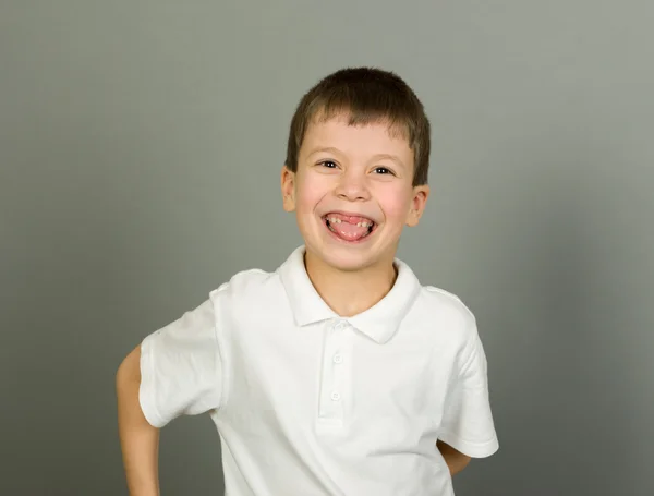 Grijnzende jongen portret op grijs — Stockfoto