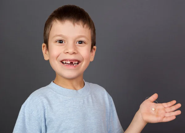 Boy with lost tooth on thread — Stock Photo, Image