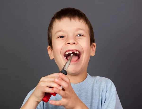 Pojke simulerar tand borttagning med tång — Stockfoto