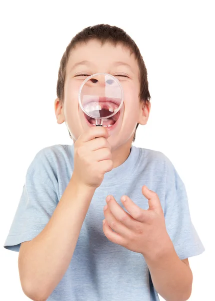 Dreng viser tabt tand gennem forstørrelsesglas - Stock-foto