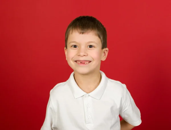 Гримасовый портрет мальчика на красном — стоковое фото