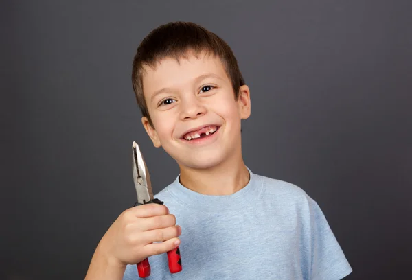 Jongen simuleert tand verwijdering met een tang — Stockfoto