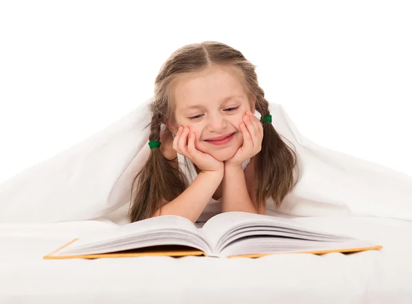 Meisje lezen boek in witte bed — Stockfoto